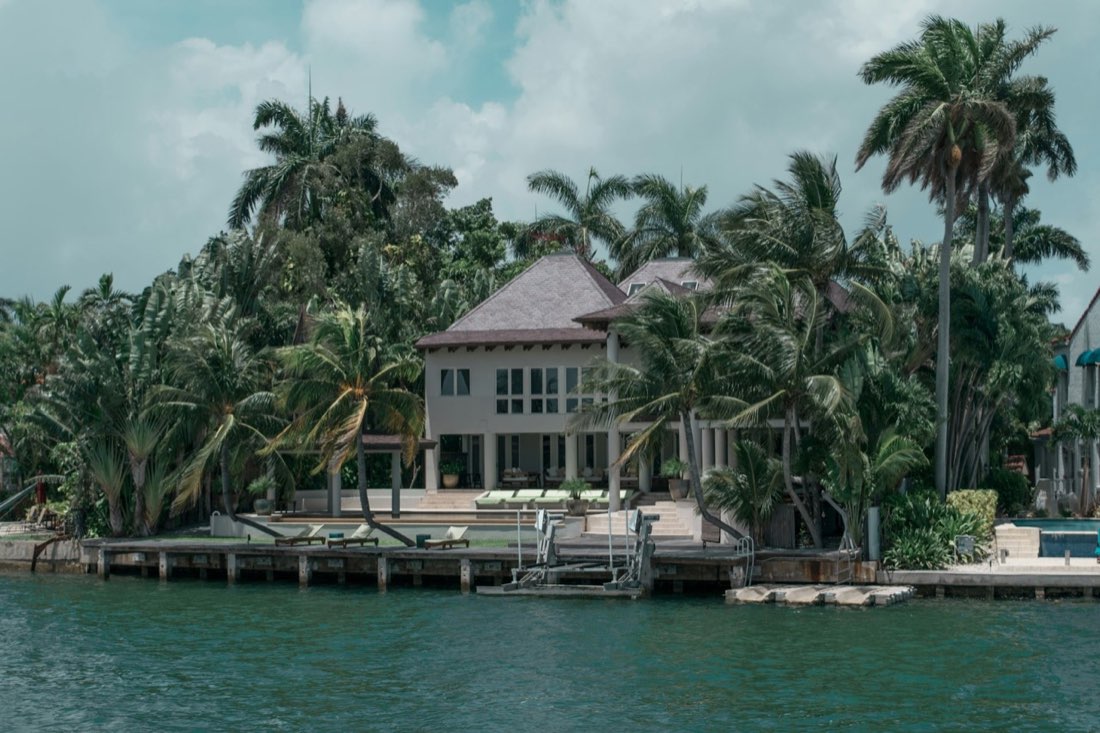 Real estate photography of a two-storey waterfront home with a private dock on a Southwest Florida canal.